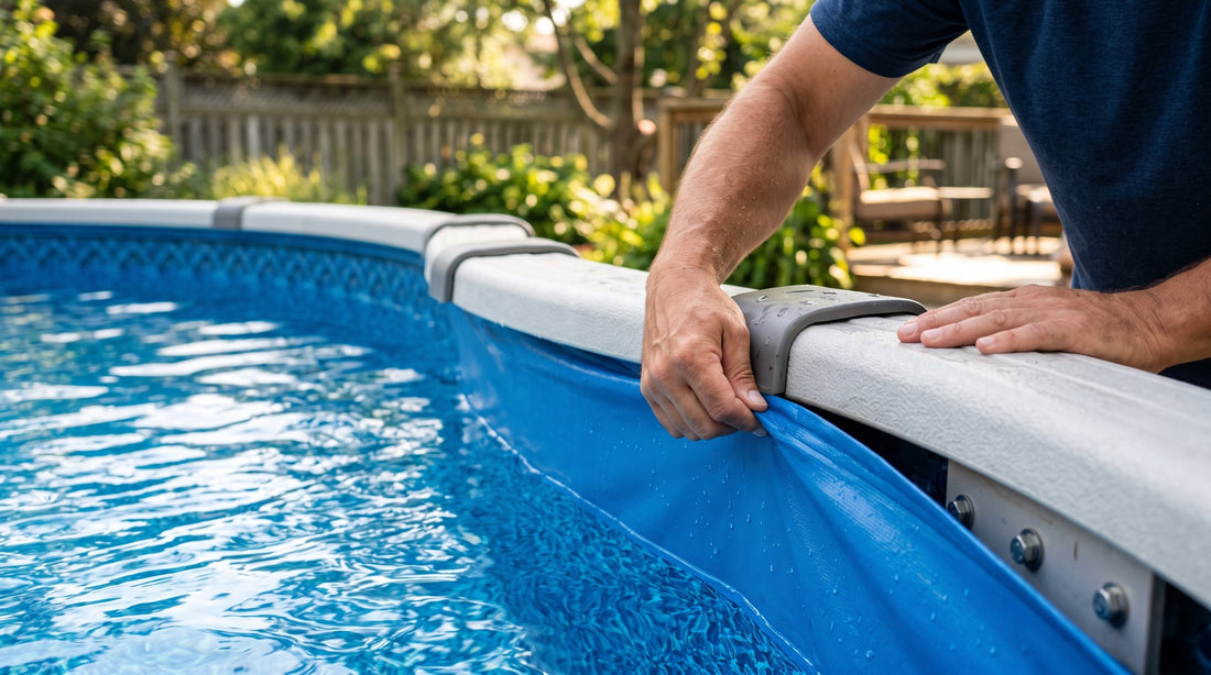 Hands tucking the blue vinyl edge of an above-ground pool liner back over the top rail