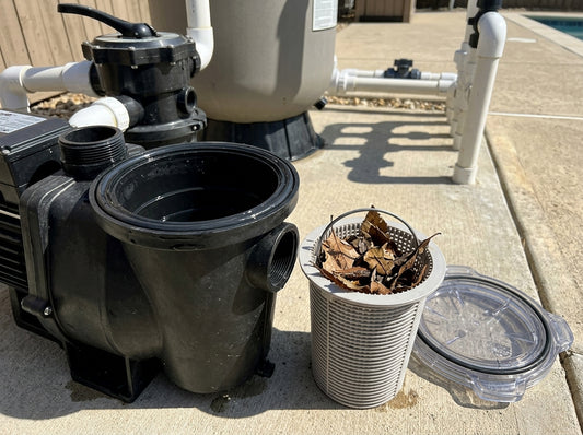 Open pool pump strainer pot with basket removed for cleaning on a daylight equipment pad