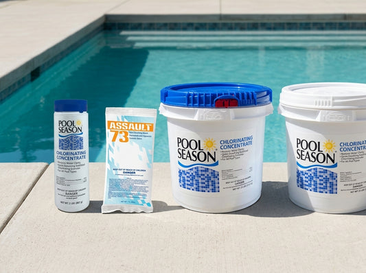Four pool shock products lined up on a pool deck in daylight